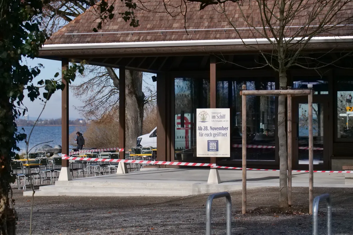 Das Seerestaurant «im Schilf» in einer Aussenansicht: Man sieht grosse Fensterscheiben und ein braunes Satteldach.